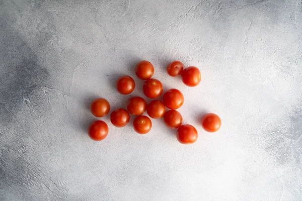 Pomidory cherry rozproszone na białym kamiennym stole betonu, widok z góry z przestrzeni kopiowania. Składniki do gotowania. — Zdjęcie stockowe