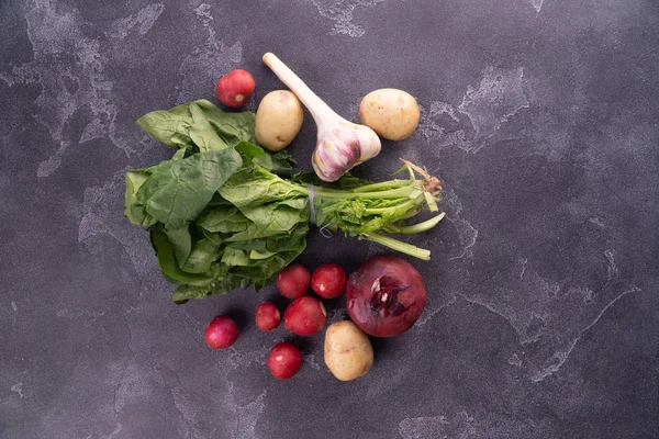 Salad leaves, garlic, reddish, potato, and onion on textured surface, top view. Healthy diet and nutrition composition. — Stock Photo, Image