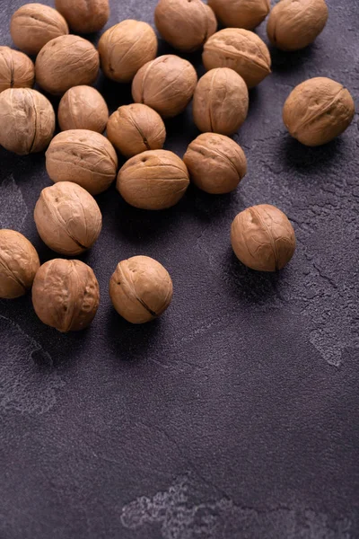 Manojo de nueces enteras sobre fondo de pizarra azul oscuro. Composición saludable de la dieta . —  Fotos de Stock