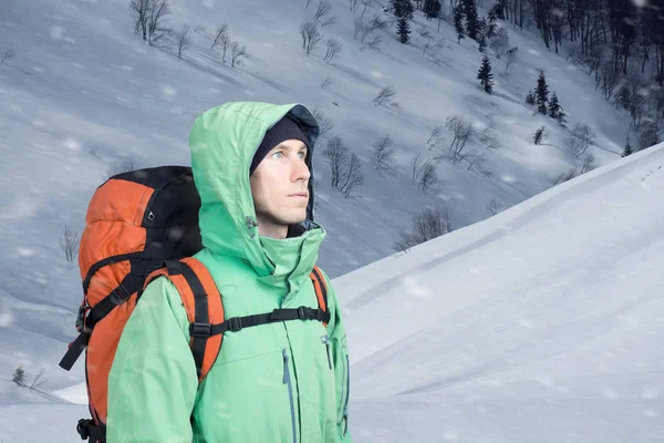 Jeune homme aventureux avec sac à dos debout sur la vue sur la montagne et regardant dehors . — Photo
