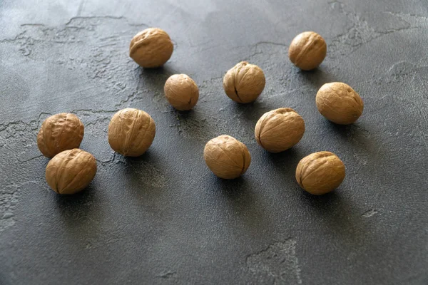 Manojo de nueces enteras en la superficie de pizarra gris. Composición saludable de la dieta . —  Fotos de Stock