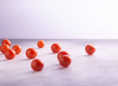 Kiraz domates beyaz taş beton masa üzerinde dağınık, kopya alanı ile. Yemek pişirmek için malzemeler.