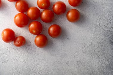 Beyaz taş beton masa üzerinde Kiraz domates, kopya alanı ile üst görünümü. Yemek pişirmek için malzemeler.