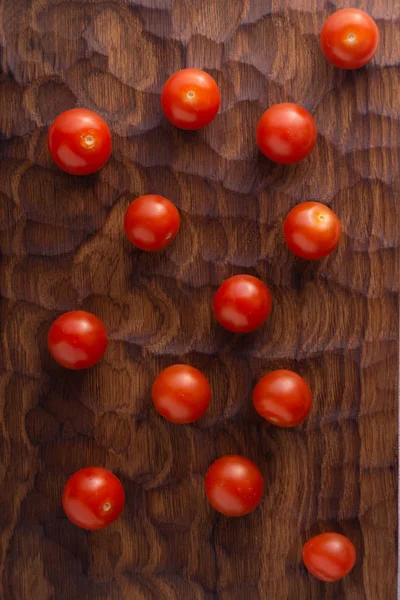 Tomates frescos sobre tabla de cortar de madera tallada. Vista superior con espacio de copia . — Foto de Stock