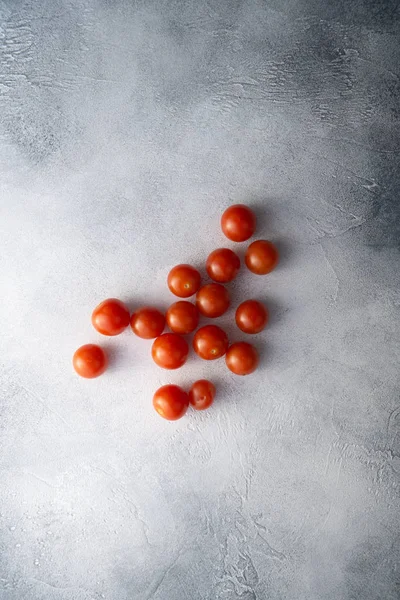 Cherry tomatoes on white stone concrete table, top view with copy space. Ingredients for cooking. — Stock Photo, Image