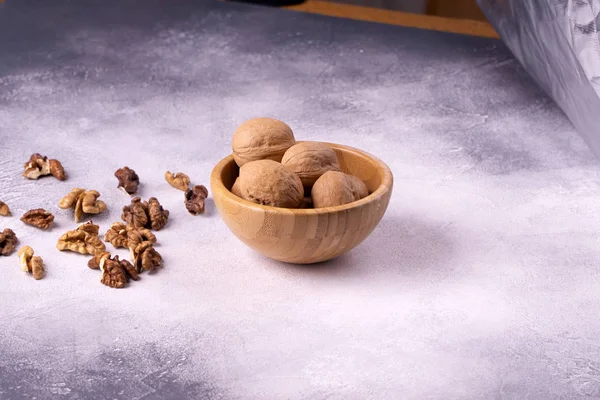 Nueces en cuenco de madera sobre superficie texturizada brillante. Composición saludable de frutos secos y semillas . —  Fotos de Stock