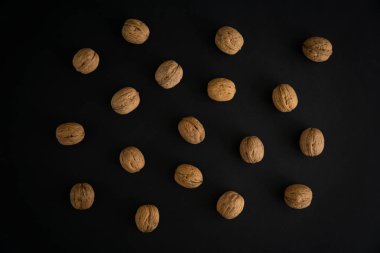 Ceviz siyah yüzey, üst görünümü üzerinde kabuk içinde. Yuvarlak ceviz arka plan. Sağlıklı fındık ve tohum bileşimi.