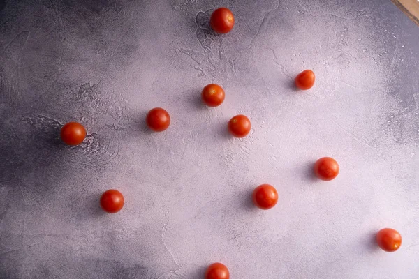 Tomates cerises éparpillées sur une table en béton de pierre blanche, vue du dessus avec espace de copie. Ingrédients pour la cuisine . — Photo