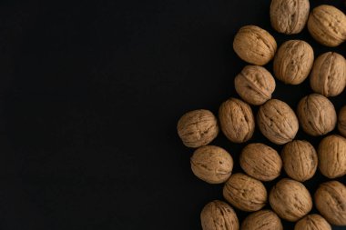 Ceviz siyah yüzey, üst görünümü üzerinde kabuk içinde. Yuvarlak ceviz arka plan. Sağlıklı fındık ve tohum bileşimi.