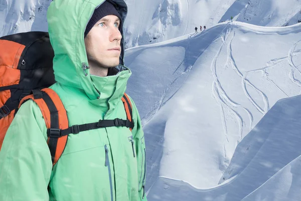 Авантюрный молодой человек с рюкзаком, стоящим на склоне горы и выглядывающим наружу. Альпинизм, экстремальный спорт . — стоковое фото