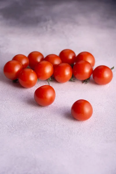 Bunch of cherry tomatoes on white stone concrete table, side view with copy space. Ingredients for cooking. — Stock Photo, Image