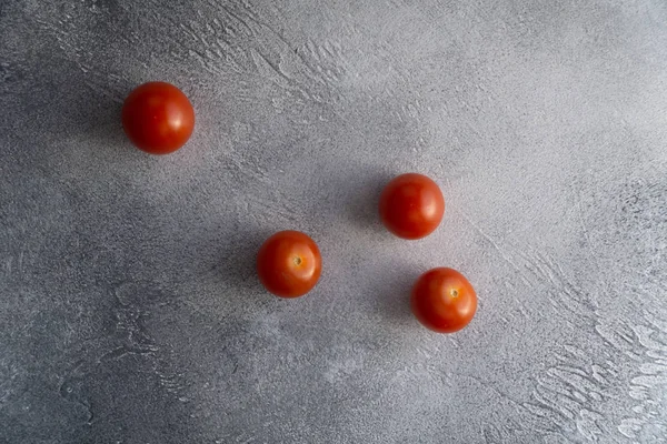 Cherry tomatoes scattered across white stone concrete table, top view with copy space. Ingredients for cooking. — Stock Photo, Image