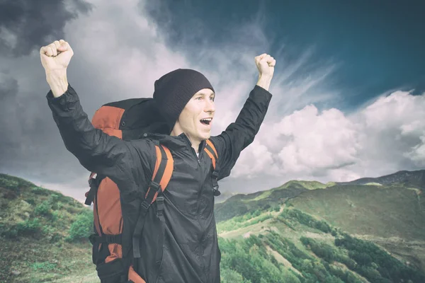 Giovane escursionista gridando in cima con le mani alzate, vista laterale . — Foto Stock