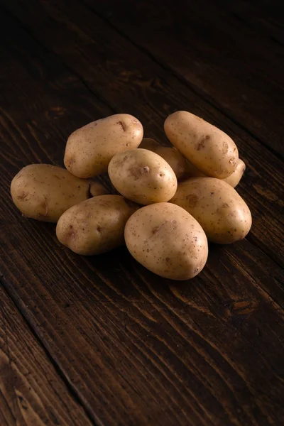Куча свежей картошки на деревенской деревянной поверхности. Органические продукты питания, углеводы, клубни . — стоковое фото