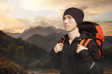 Dağda yürüyüş aktif genç adam, bulutlu manzara arka plan üzerinde yan görünüm. Aktif yaşam tarzı ve turizm.