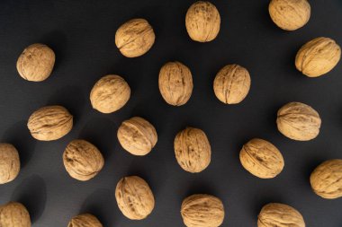 Ceviz siyah yüzey, üst görünümü üzerinde kabuk içinde. Yuvarlak ceviz arka plan. Sağlıklı fındık ve tohum arka plan.