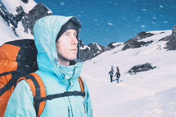 Jeune homme aventureux avec sac à dos debout sur la vue sur la montagne et regardant dehors. Snowboarders marchant en montée pour freeride, sport extrême . — Photo