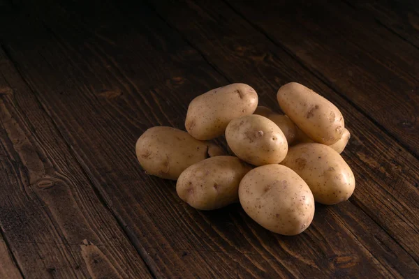 Halom friss burgonya rusztikus fa felületre. Bioélelmiszerek, szénhidrákák, gumók. — Stock Fotó