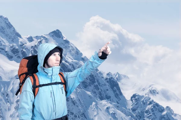 Retrato de un joven aventurero en la cima de la montaña de invierno señalando . —  Fotos de Stock