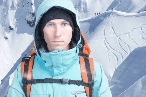 Young male mountain climber on winter mountain-side view looking at camera. Front view. Active lifestyle in cold weather. — ストック写真