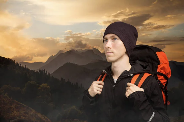 Aktywny młody człowiek wędrówki w górach, widok z boku na pochmurny tle krajobrazu. Aktywny styl życia i turystyka. — Zdjęcie stockowe