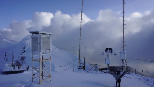 Зимняя метеостанция в горах Кавказа на движущемся фоне облаков. Временной интервал . — стоковое видео