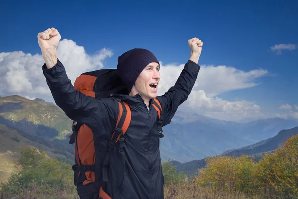 Junger Wanderer schreit mit erhobenen Händen nach oben, Seitenansicht. — Stockfoto