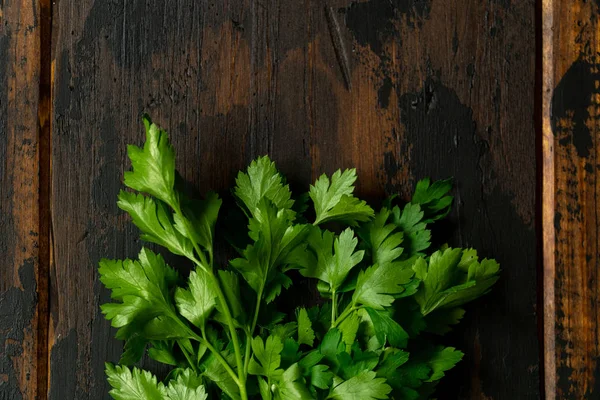 Bir demet yeşil maydanoz, tahta rustik masada kişniş. Üstte görüntü.