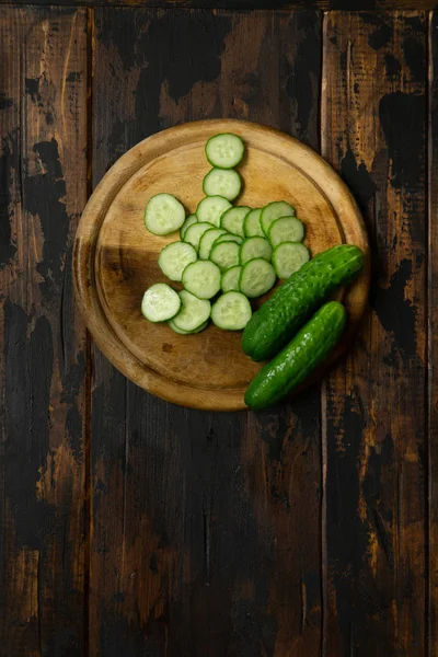 Komkommer in wielen gesneden. Komkommer op een houten snijplank. Sneetjes komkommer. — Stockfoto
