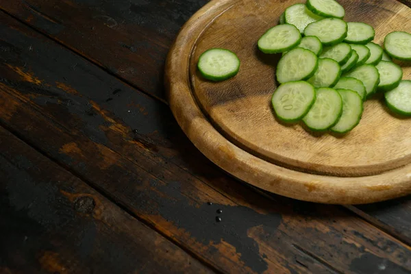 Pepino cortado em rodas. Pepino em uma placa de corte de madeira. Fatia de pepino . — Fotografia de Stock