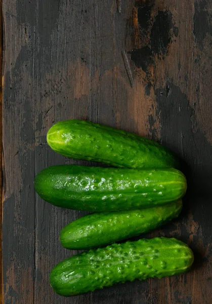 Fresh green cucumbers on a old wooden table. Organic food. — Stock Photo, Image