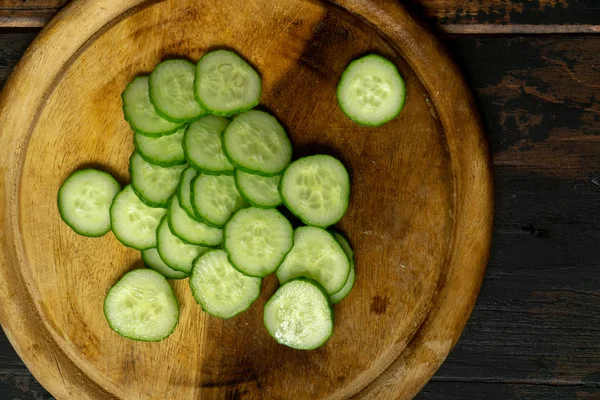 Komkommer in wielen gesneden. Komkommer op een houten snijplank. Sneetjes komkommer. — Stockfoto