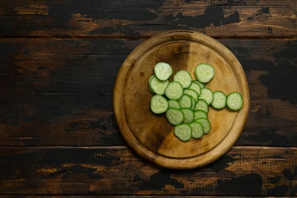 Cucumber cut into wheels. Cucumber on a wooden cutting board. Slices of cucumber. — Stock Photo, Image