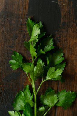 Bir demet yeşil maydanoz, tahta rustik masada kişniş. Üstte görüntü.