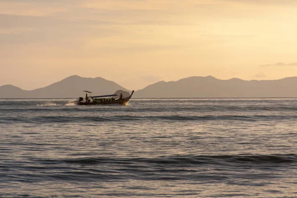 Akşam ada tarafından geleneksel uzun tekne yelken, Tayland.