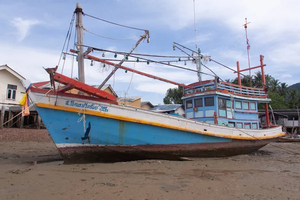 Tradycyjna Tajska łódź rybacka i drewniane domy przy niskiej pływów plaży, Phangan Island, Tajlandia. — Zdjęcie stockowe