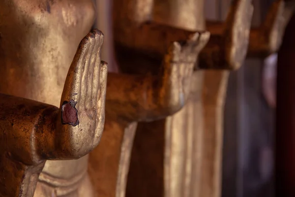 Mãos envelhecidas desgastadas de bronze antigo estátuas de Buda no templo . — Fotografia de Stock