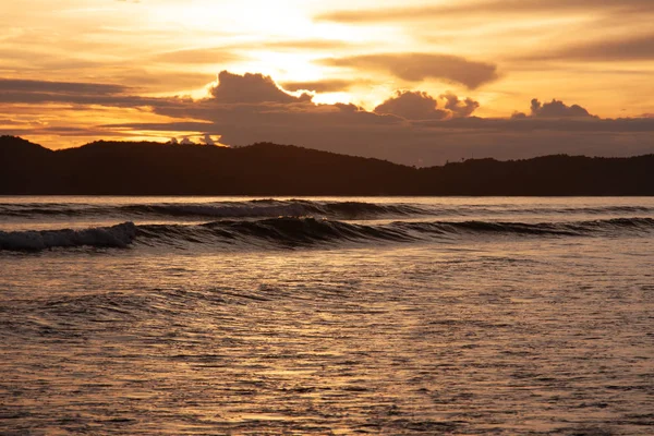 Sonnenuntergang an der Strandkulisse mit Meerblick, Wolken und Wellen. Schönheit der Natur. — Stockfoto