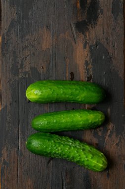 Eski ahşap bir masada taze yeşil salatalık. Organik gıda.