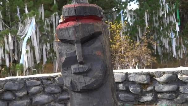 Alte hölzerne heidnische Götzenkopf auf rituellen Bändern heiliger Baumhintergrund im Altai-Gebirge. — Stockvideo