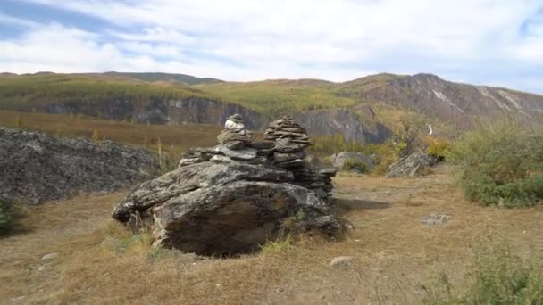 背景にシベリアの風景と石のピラミッドのクローズアップ. — ストック動画