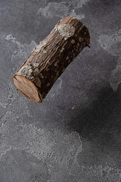 Seção de tronco de árvore pairando sobre a superfície de concreto escuro. — Fotografia de Stock