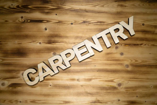 CARPENTRY palabra hecha de letras de madera sobre tabla de madera. — Foto de Stock