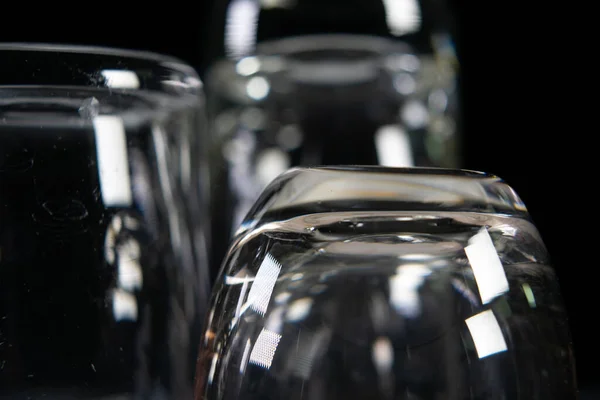 Three empty shot glasses on black background. — Stock Photo, Image