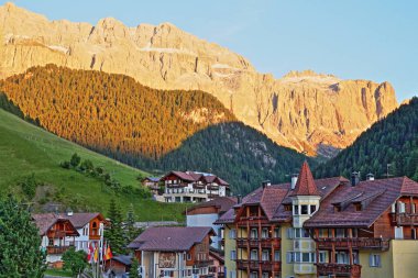 Selva ön planda, Val Gardena, Dolomites, İtalya geleneksel evleri görülüyor Sella grup dağlar üzerinde renkli günbatımı