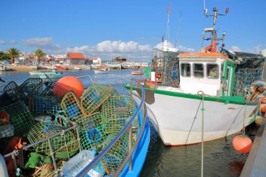Balıkçı limanı, Santa bir İskelesi demirleme ve sepetleri ön planda balıkçılık renkli balıkçı tekneleri ile Tavira, Algarve, Portekiz, yanında bulunan Luzia,
