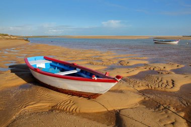 Renkli plaj Cacela Velha üzerinde günbatımında demirleme tekneler, küçük bir köy Tavira, Algarve, Portekiz yer alan