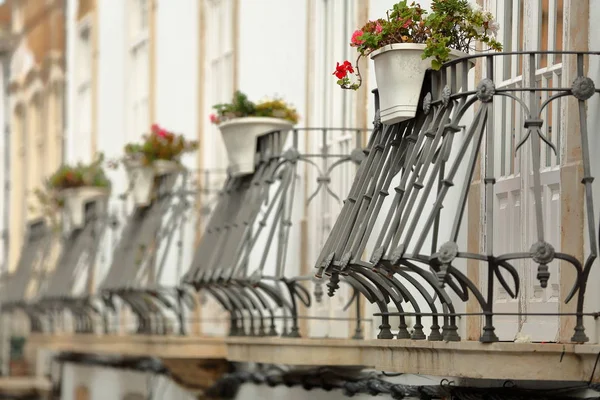 Close-up on a row of typical wrought iron railing balconies inside the old town of Tavira, Algarve, Portugal