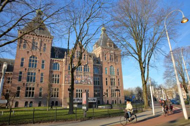 Amsterdam, Hollanda - 14 Şubat 2019: Dış cephe Tropenmuseum insanlarla ön planda Bisiklete binme