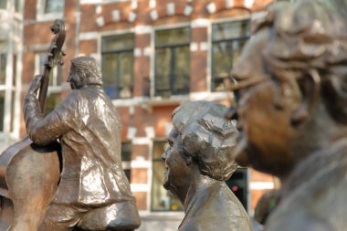 AMSTERDAM, NETHERLANDS - APRIL 05, 2019: Bronze Sculptures of famous Dutch musicians and singers (Johnny Meyer, Johnny Jordaan and Manke Nelis), located on Elandsgracht (close to Prinsengracht canal)
